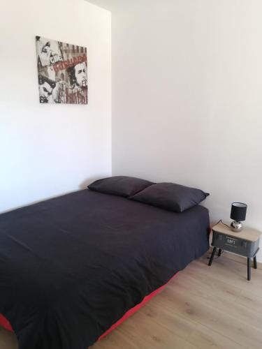 a bedroom with a black bed and a table at Marina & Alex in Château-Gaillard