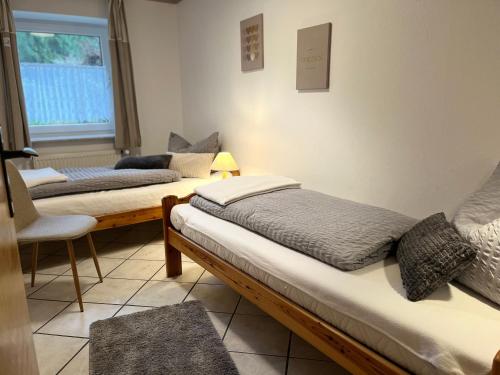 a room with three beds and a chair and a window at Ferienhof Tödter in Schneverdingen