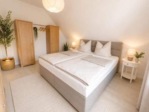 a bedroom with a large bed with white sheets at Ferienwohnung Rita Usedom in Korswandt