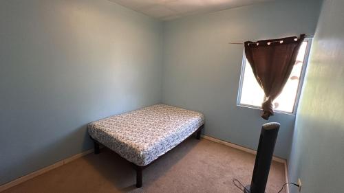 a small room with a bed and a window at Casa San Carlos in La Coyotera