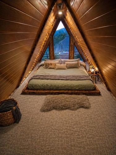 a bedroom with a bed in a wooden tent at Maria's Cabin & Spa in Băiaşu