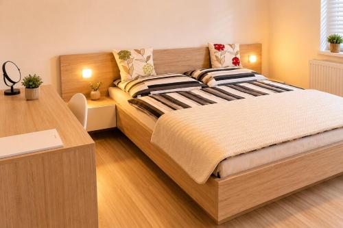 a bedroom with a large bed with a desk at Apartman Pred polom in Trenčín