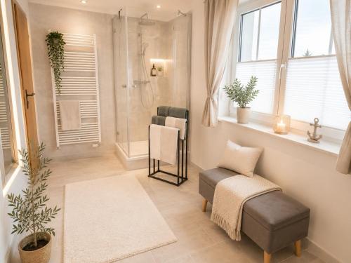 a bathroom with a shower and a bench and a chair at Ferienwohnung Rita Usedom in Korswandt