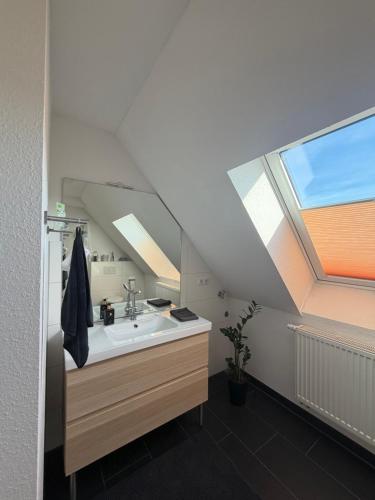 ein Badezimmer mit Waschbecken und Dachfenster in der Unterkunft Falltor Living in Rees