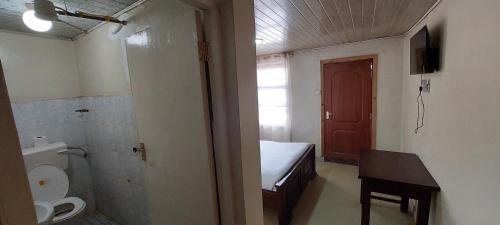 a small bathroom with a toilet and a sink at Crown Accommodation Narok in Narok