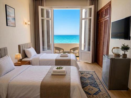 a hotel room with two beds and a view of the ocean at New Hyde Park House Hotel in Alexandria
