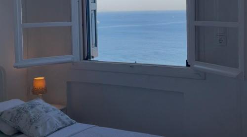 a bedroom with a window with a view of the ocean at Chez Semiramis The Sun Touch House for 8 persons 5'min from the beach in Rámos