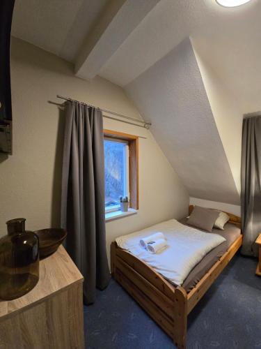 a small bedroom with a bed in a attic at Hotel Zur Luppbode in Treseburg