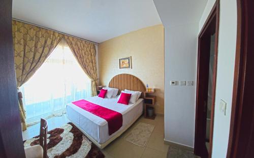 a bedroom with a bed with a large window at Luxury Skyline Apartment with Panoramic Views in Sharjah