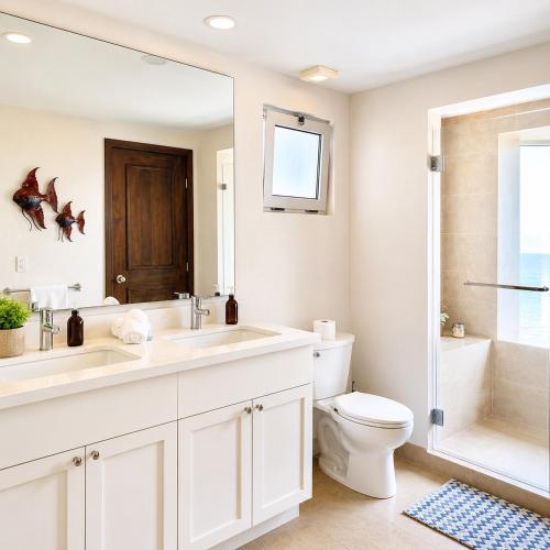 a bathroom with two sinks and a toilet and a shower at Luxury Beachfront Condo at Krystal Grand Resort - NEWLY REMODELED & NEWLY FURNISHED in Bucerías