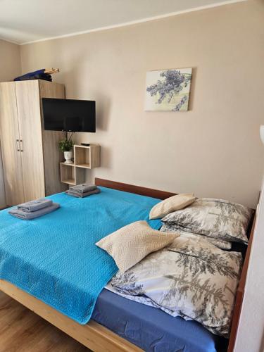 a bedroom with a bed with a blue blanket at Duet in Władysławowo