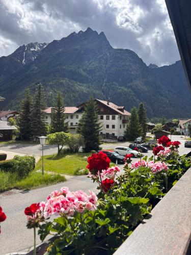 a bunch of flowers in a parking lot with mountains at Irmas Ferienhäusl in Längenfeld