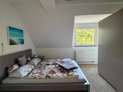 ein Schlafzimmer mit einem Bett in einem Zimmer mit Fenster in der Unterkunft Falltor Living in Rees