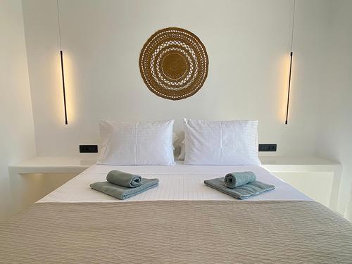 a bedroom with a bed with two towels on it at CHARMA Mykonos in Kalo Livadi