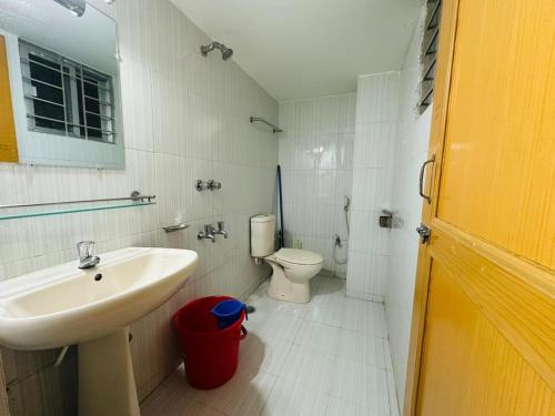 a white bathroom with a sink and a toilet at Vacation House a Service Apartment in Cox's Bazar