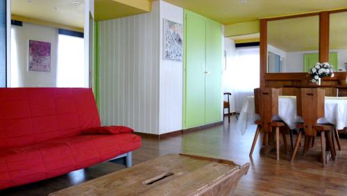 un salon avec un canapé rouge et une table dans l'établissement Lina et Anaë, à Saint-Nabor
