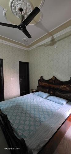 a bedroom with a bed with a ceiling fan at StayStudio in Jammu
