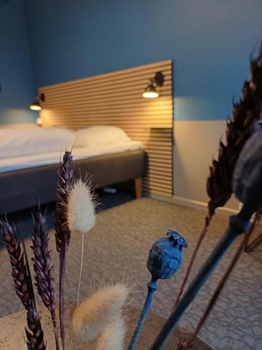 a bedroom with a bed and some dried plants at Double Room 8 on pedestrian street Saeby in Sæby