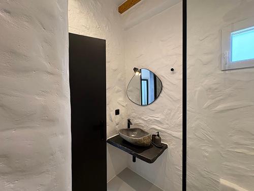 a bathroom with a sink and a mirror on the wall at CHARMA Mykonos in Kalo Livadi
