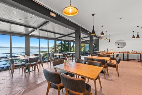 ein Restaurant mit Tischen und Stühlen und Meerblick in der Unterkunft Hotel Vali Dramalj in Crikvenica