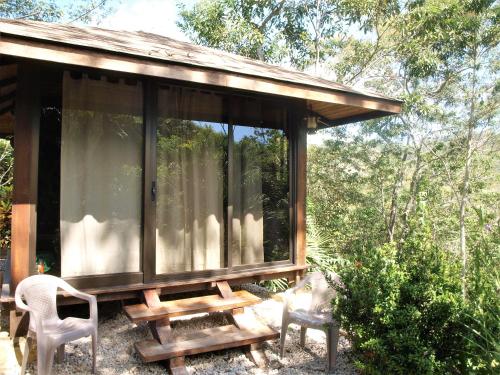 a cabin with a table and chairs in the woods at Lodge Margouillat in Tambor