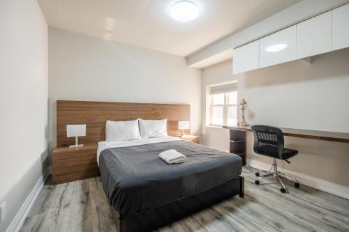 a bedroom with a bed and a desk and a chair at Spadina Boutique Rooms in Toronto