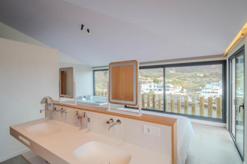 a bathroom with two sinks and a large window at Villa Vista Suite by Aura Collection in Tamaduste