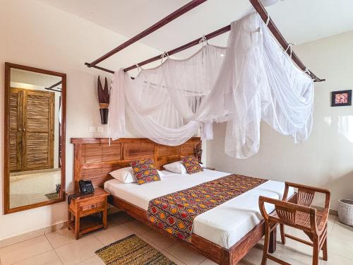a bedroom with a bed with a mosquito net at Le Lodge des Almadies in Dakar