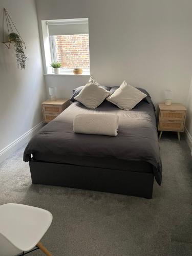 a bedroom with a bed with two pillows and a window at 2 bed- walkable train and beach apartment in Crosby