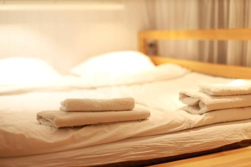 three folded towels sitting on top of a bed at The ALL-in-ONE LOFT with AIRPORT pickup in Ulaanbaatar