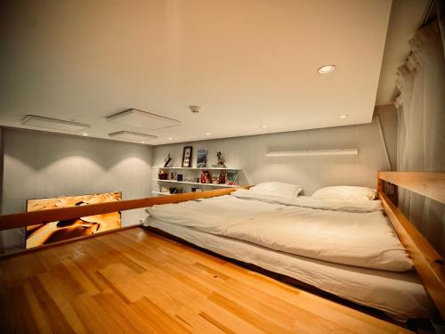 a large bed in a room with a wooden floor at The ALL-in-ONE LOFT with AIRPORT pickup in Ulaanbaatar
