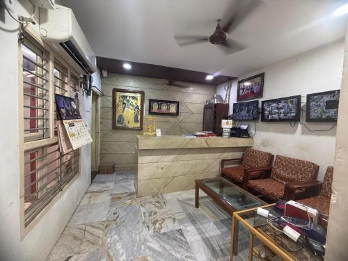 a waiting room with a couch and a bar at Raya's Executive Homes in Kumbakonam