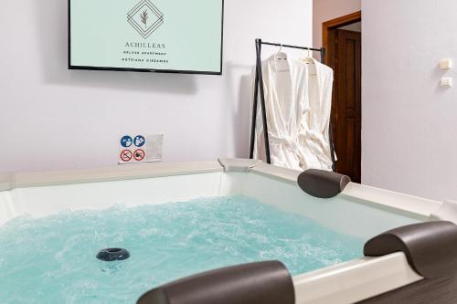 a jacuzzi tub with a chair in a room at Achilleas Deluxe House-Jacuzzi - BBQ in Kotsianá
