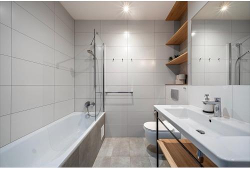 a bathroom with a tub and a sink and a toilet at Mechelinki Enjoy in Mechelinki