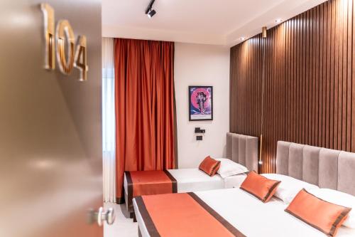 a hotel room with two beds and red curtains at Ambrosia Room & Apartment in Rossano