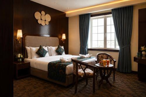 a hotel room with a bed and a table and a window at Alasha Retreat in Srinagar