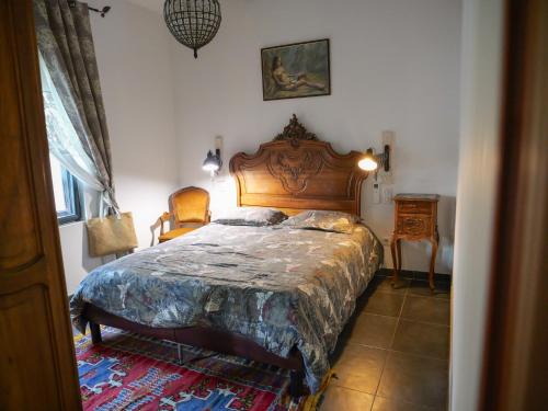 a bedroom with a large bed with a wooden headboard at Les Boissèdes in Les Vans