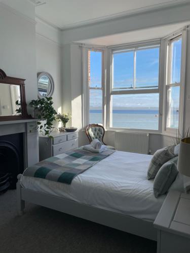a bedroom with a bed with a view of the ocean at Beds at 46, Cowes in Cowes