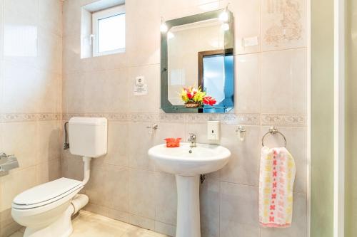 a bathroom with a sink and a toilet and a mirror at Casa Buga in Telega