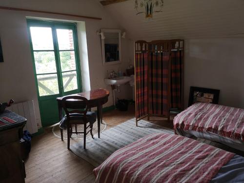 a bedroom with a bed and a desk and a table at Cottage LAISSER VERDURE in Gargilesse-Dampierre