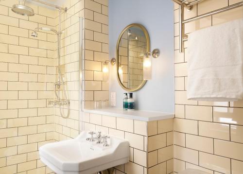 a white bathroom with a sink and a mirror at The Royal Lion Hotel in Lyme Regis