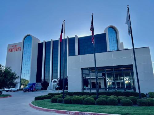 a building with flags in front of it at The Arlin, Arlington, a Tribute Portfolio Hotel in Arlington