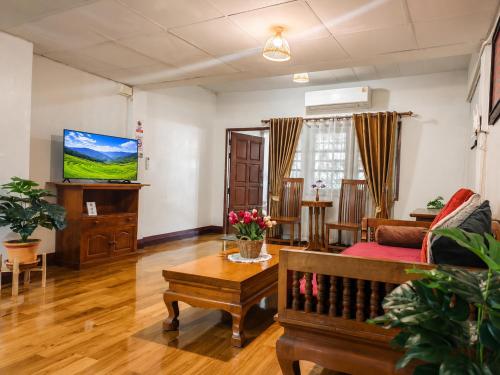a living room with a couch and a table at Aphilapa House in Chiang Mai
