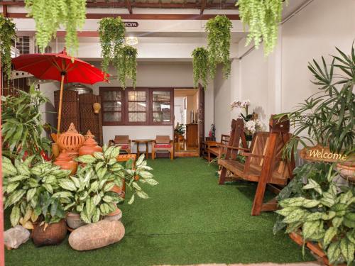 a room with a green floor with plants and an umbrella at Aphilapa House in Chiang Mai