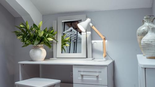 a desk with a lamp and a picture and a plant at Bilidowcar in Menai Bridge
