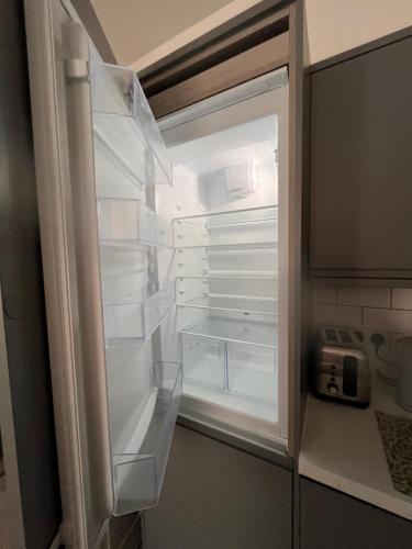 an empty refrigerator with its door open in a kitchen at Stunning 2 bed apartment - central Norwich in Norwich