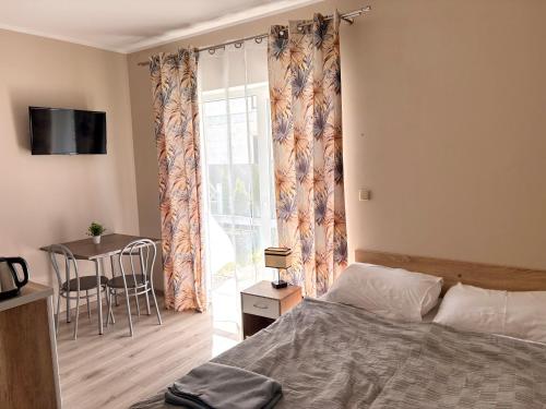 a bedroom with a bed and a table and a window at Villa Rowena in Rowy