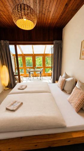 a bedroom with two beds and a large window at Mountain View Room mit sonnigem Wintergarten in Dietmannsdorf bei Trieben