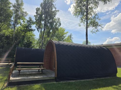 a shed with a bench in the grass at 44 Camping Pod "Dieksee" in Silberstedt