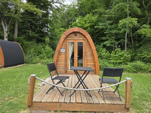 a wooden deck with two chairs and a cabin at 39 Mini Pod "Treene" in Silberstedt